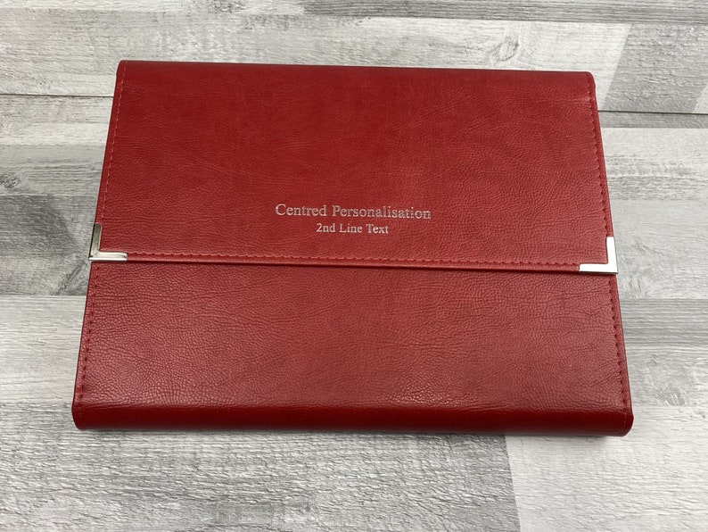 Red cabrini board-supported document wallet front cover with square nickel corners and silver foil personalisation in the centre of the wallet.