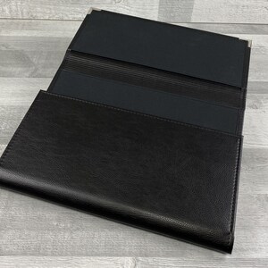 Inside of Cabrini board-supported document wallet with square nickel corners. Lined in black book cloth.