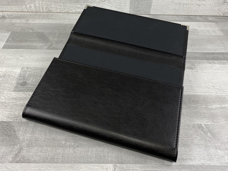 Inside of Cabrini board-supported document wallet with square nickel corners. Lined in black book cloth.