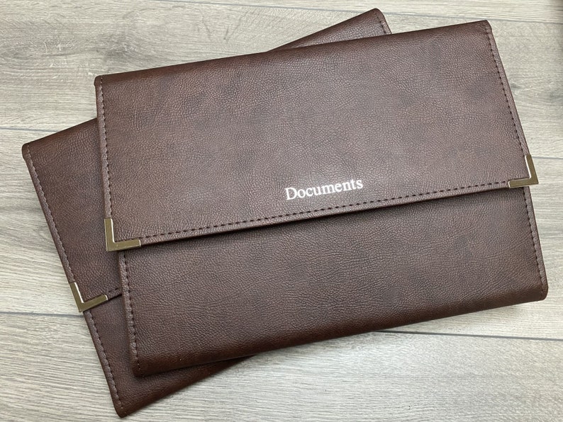 Brown cabrini board-supported document wallets front cover with square nickel corners and silver foil personalisation in the centre of the wallet that reads documents.