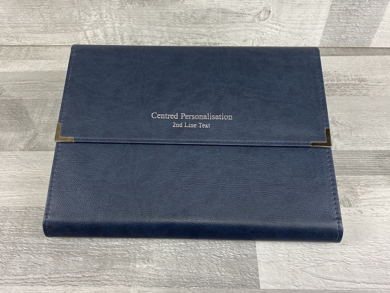 Navy cabrini board-supported document wallet front cover with square nickel corners and silver foil personalisation in the centre of the wallet.