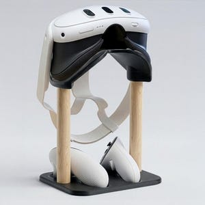 May include: A white and black VR headset and controllers are displayed on a wooden stand. The stand has a black base and two wooden posts. The headset is white with black accents, and the controllers are white.