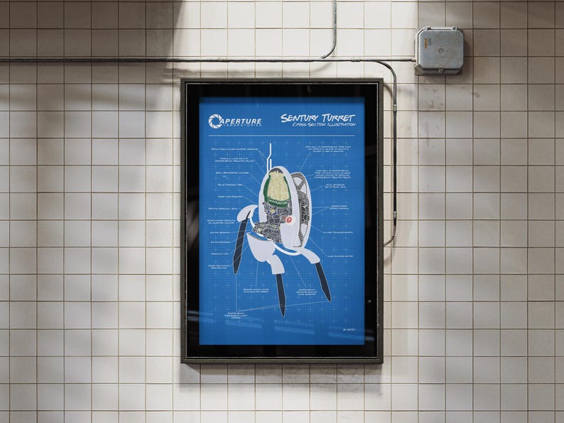 May include: A framed poster featuring a blueprint-style illustration of a "Sentry Turret" from the video game Portal. The poster has a blue background with white and black details, and is mounted on a tiled wall.