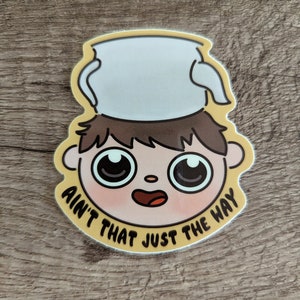 May include: Yellow sticker with a cartoon character wearing a white bucket hat and the text "Ain't that just the way".
