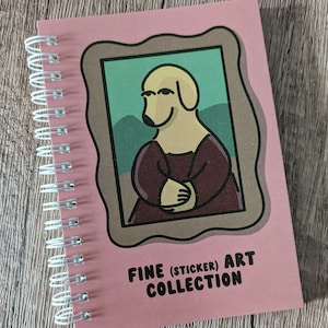 May include: A pink spiral bound notebook featuring a cartoon dog in a painting frame. The cover text reads "Fine (Sticker) Art Collection".