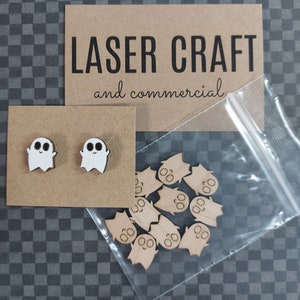 Puede incluir: Primer plano de un paquete que contiene recortes de fantasmas de madera. El paquete incluye dos pequeños pendientes de fantasmas y una bolsa de recortes de fantasmas más grandes. El paquete está etiquetado como "LASER CRAFT and commercial."