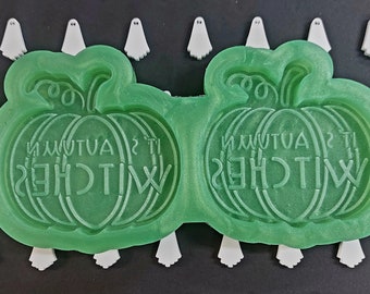 Pode incluir: Forma de silicone verde para fazer duas guloseimas em forma de abóbora. A forma apresenta o texto "It's Autumn Witches".
