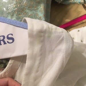 May include: White mesh fabric with a white trim. The fabric is slightly wrinkled and has a few small stains.