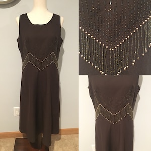 May include: A brown sleeveless dress with a beaded neckline and a beaded design on the bodice. The beads are gold and brown.