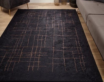 Könnte beinhalten: Ein schwarzer und goldener Teppich mit geometrischem Muster. Der Teppich hat einen dezenten Glanz und ein modernes Design.