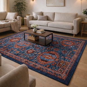 Könnte beinhalten: Eine weiße Keramik-Tasse mit schwarzem Henkel und dem Text "But First, Coffee" in fetter, schwarzer Schrift. Die Tasse steht vor einem verschwommenen Hintergrund, der eine gemütliche Umgebung suggeriert.