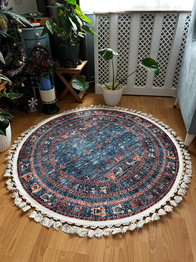 May include: A round blue and red patterned rug with white fringe. The rug has a geometric design with a central medallion.