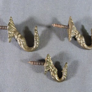 Three gilt bronze curtain hooks