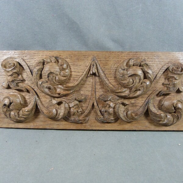 Renaissance-style carved oak bas-relief decorated with 4 grotesque heads spitting foliage