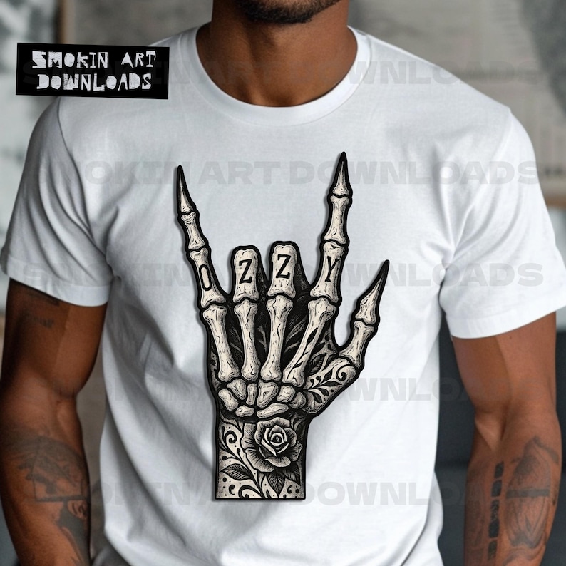 Puede incluir: Camiseta blanca con una ilustraci&oacute;n detallada de una mano de esqueleto haciendo el gesto de 'rock on', con la palabra 'OZZY' escrita en el centro. La mano tiene tatuajes florales. La esquina superior izquierda tiene el texto 'SMOKIN ART DOWNLOADS'.