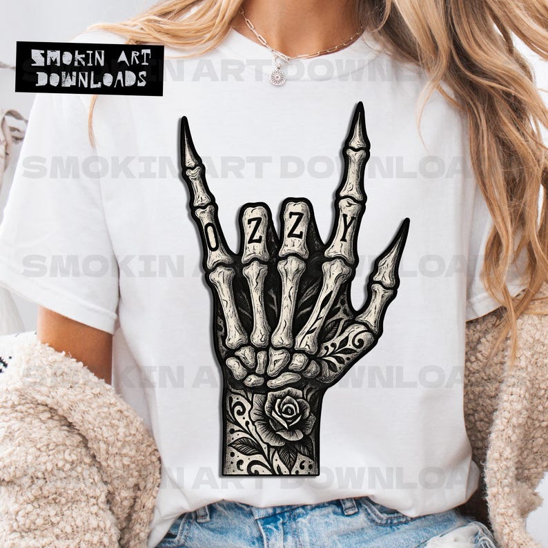 Puede incluir: Camiseta blanca con una ilustraci&oacute;n en blanco y negro de una mano esquel&eacute;tica haciendo el gesto de rock. La palabra "OZZY" est&aacute; escrita en los dedos. Un dise&ntilde;o de rosa y hojas est&aacute; en la mu&ntilde;eca. El texto "SMOKIN ART DOWNLOADS" est&aacute; en la esquina superior izquierda.
