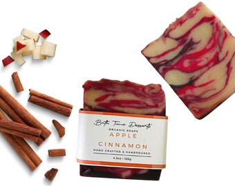 May include: A bar of handmade organic soap with a red and white swirl pattern. The soap is labeled "Bath Time Desserts Organic Soaps Apple Cinnamon Hand Crafted & Handpoured 4.5 oz | 128g".