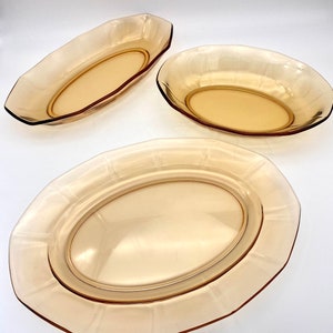 Puede incluir: Juego de tres platos ovalados para servir de vidrio &aacute;mbar. Los platos tienen un borde elevado y una superficie lisa ligeramente texturizada.