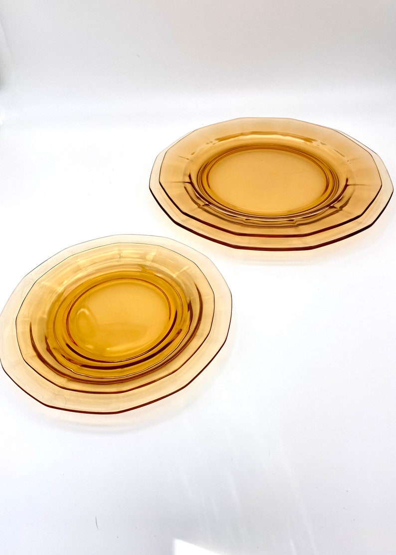 Puede incluir: Dos platos de vidrio &aacute;mbar con borde festoneado. Los platos est&aacute;n apilados uno encima del otro.