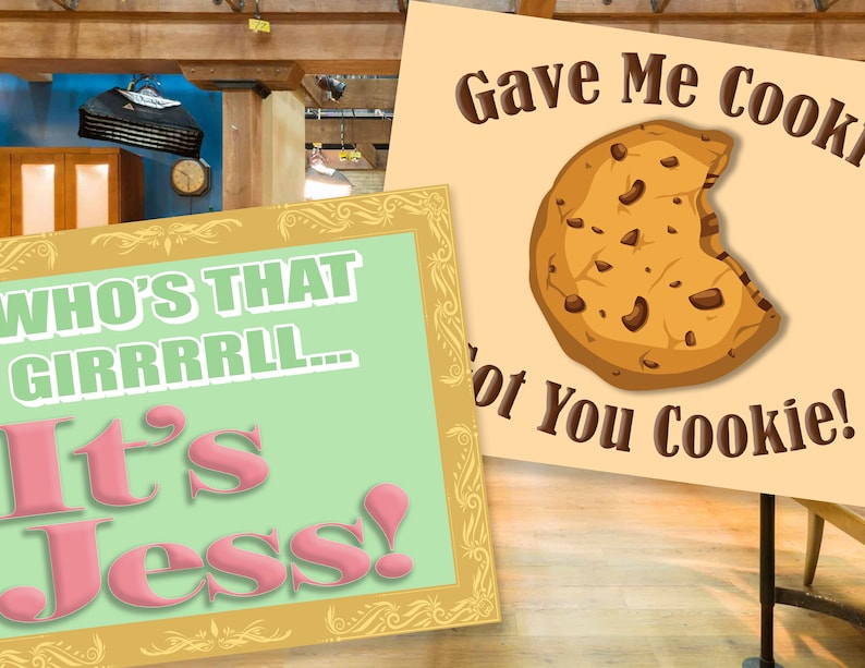 May include: Two signs with a green and pink background. The first sign says "Who's that girrrrl... It's Jess!" The second sign says "Gave me cookie, not you cookie!" with a cartoon image of a chocolate chip cookie.