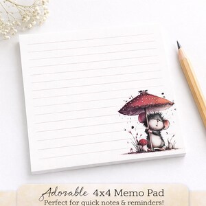 May include: A 4x4 inch lined memo pad with an illustration of a mouse under a mushroom umbrella. The mouse is gray and white, and the umbrella is red with white spots. A pencil rests on the right side of the pad.