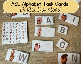 以下が含まれることがあります： 手話で学ぶためのASLアルファベットタスクカードのセット。カードの片面には文字が、もう片面には対応する手話の手のジェスチャーが書かれています。カードは木製の表面に置かれています。