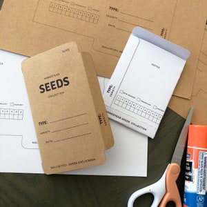 May include: Brown paper envelopes with a white label that says "Homestead Seeds Collection". The envelopes have spaces to write the type, variety, and date of the seeds. There is a grid on the label to track the sowing, transplanting, and harvesting of the seeds.