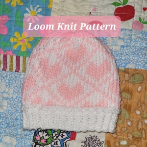 May include: Pink and white loom knit hat with a white crocheted brim. The hat is on a colorful patchwork quilt.