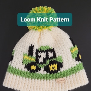 May include: White knitted hat with a green and yellow pom pom on top. The hat has a green and white striped band and a black and green tractor design. The hat has a brown tag that says "Handmade".