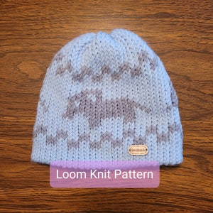 May include: A blue and gray striped knit hat with a brown "Handmade" tag. Loom Knit Pattern.