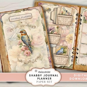 May include: A vintage-style journal planner with a floral and bird design. The cover features a watercolor painting of a blue bird perched on a branch with pink flowers. The journal is open, revealing pockets and a weekly calendar. The text "Journal Planner" is visible.