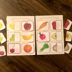 May include: A set of matching game cards featuring various fruits and vegetables. The cards are divided in half, with one half showing the whole fruit or vegetable and the other half showing a cut-out section. The cards are labeled "Tilda the awesome fruit!" and "Tilda the awesome veggie!"