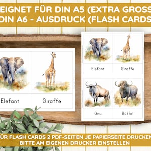 May include: Educational flash cards featuring watercolor illustrations of African animals: an elephant, giraffe, wildebeest, and buffalo. Each card displays the animal's name in German. The cards are designed for A5 and A6 printing.