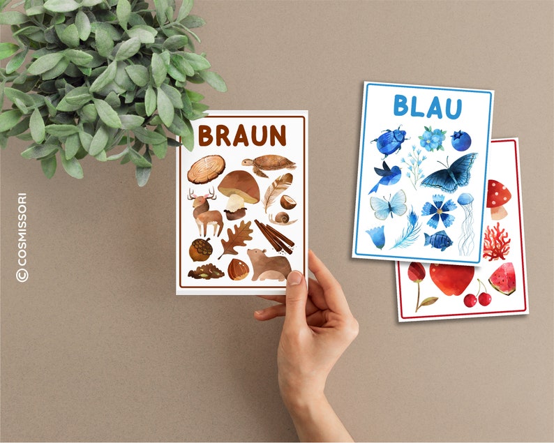 May include: Three color flashcards with German words for blue, brown, and red. Each card features watercolor illustrations of objects in the corresponding color.