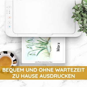 May include: A white printer with a sheet of paper in the tray. The paper has a watercolor illustration of a snowdrop flower with the word "M&auml;rz" (German for March) on it. The text "BEQUEM UND OHNE WARTEZEIT ZU HAUSE AUSDRUCKEN" (German for "Convenient and without waiting time to print at home") is at the bottom of the image.