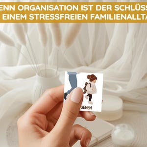 May include: A white card with a cartoon illustration of a person walking. The text on the card reads "GEHEN".