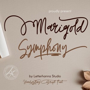 May include: A digital graphic featuring the words "Marigold Symphony" in a flowing, handwritten font. The design includes the text "proudly present" and "by Letterhanna Studio". The background is a neutral beige with decorative elements.