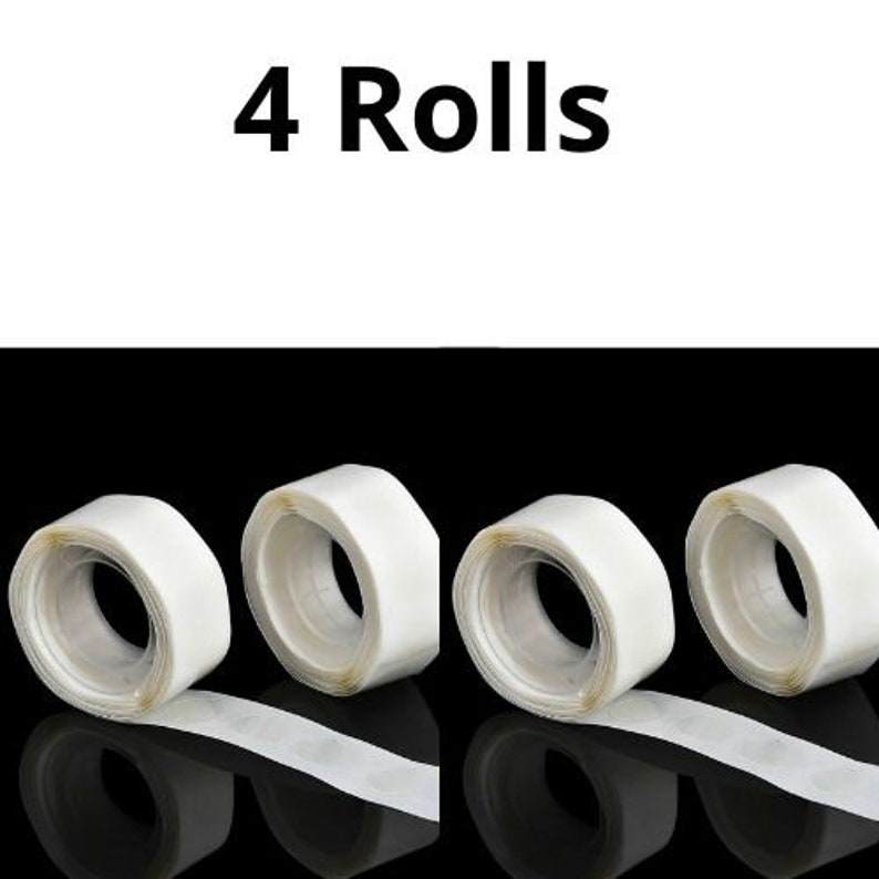 May include: Four rolls of clear double-sided adhesive tape. The tape is on a white background.