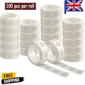 May include: A roll of 100 clear adhesive dots, perfect for crafts, home decor, and more. The dots are shown in multiple rolls, with some rolls partially unrolled to show the individual dots.