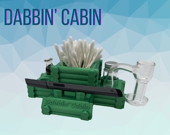 May include: A green, 3D printed, cabin-shaped organizer with the words "Dabbin' Cabin" on the front. The organizer has compartments for a dab rig, a small bottle, and cotton swabs.