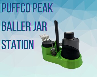May include: A green plastic Puffco Peak Baller Jar Station with a black and gray Puffco Peak vaporizer, a glass jar, and cotton swabs.