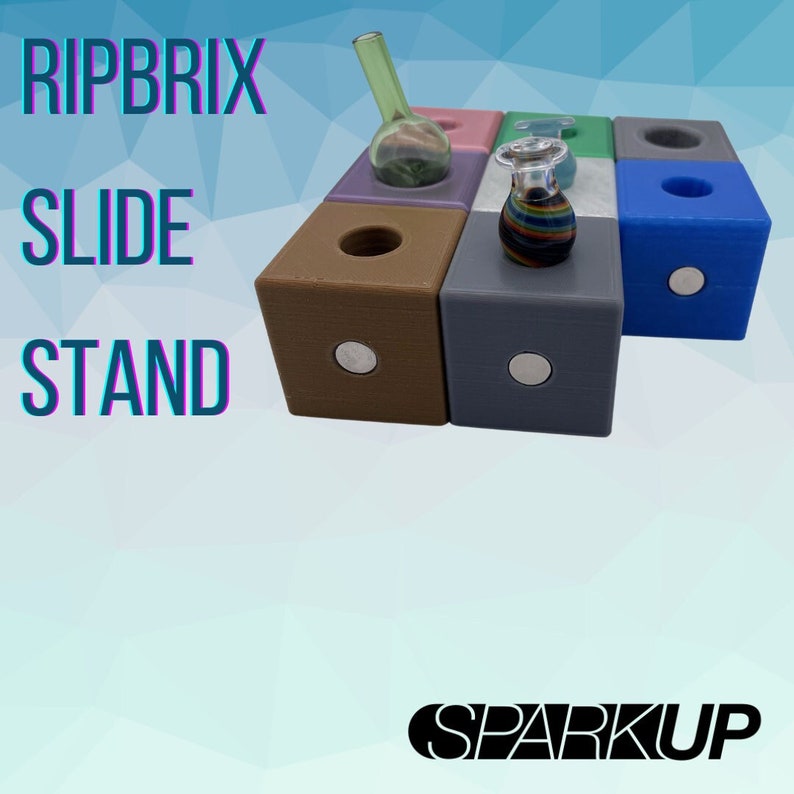 Puede incluir: Un conjunto de seis soportes magn&eacute;ticos de colores para sujetar portaobjetos de vidrio, bongs u otros accesorios para fumar. Los soportes est&aacute;n hechos de pl&aacute;stico texturizado y tienen una base magn&eacute;tica. El texto "RIPBRIX SLIDE STAND" es visible en la imagen.