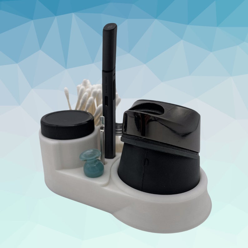 K&ouml;nnte beinhalten: Wei&szlig;er Organizer mit einem schwarzen Stift, einem kleinen Glas, einem schwarzen und silbernen Elektrorasierer und Wattest&auml;bchen.