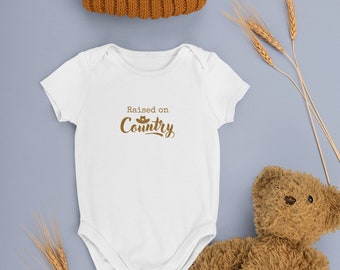 Country music merchandise baby bodysuit ‘raised on country’ baby clothing festival merch custom clothing bodysuit country music gift