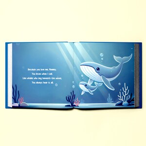 May include: An open book with a blue cover and a light blue background. The book features an illustration of two whales swimming in the ocean. The text on the page reads: "Because you love me, Mommy, You listen when I call. Like whales who sing beneath the waves. You always hear it all."