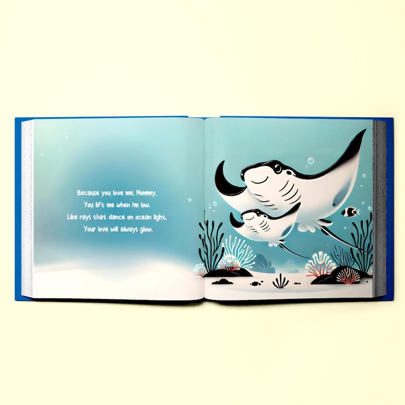 May include: An open book with a blue cover. The page shows an illustration of two manta rays swimming in the ocean. The text on the page reads: "Because you love me, Mommy, You lift me when I'm low. Like rays that dance on ocean light, Your love will always glow."