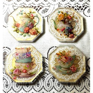 May include: Four octagonal coasters with a gold background and white lace trim. Each coaster features a different vintage teacup or teapot design with floral accents.
