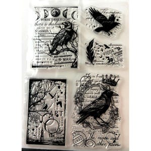 May include: A set of clear silicone stamps featuring black ink designs of ravens, feathers, moon phases, and vintage-style postal labels. The stamps include text such as "WHERE THERE IS LIGHT there is shadow", "AIR MAIL", "91004", "3p", and "1932".