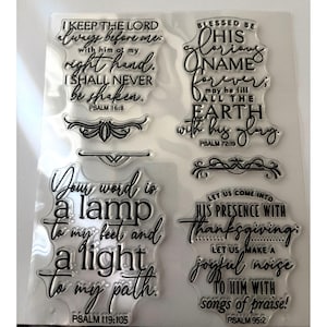 May include: Clear acrylic stamps with inspirational quotes from the Bible. The stamps feature phrases like "I keep the Lord always before me" and "Your word is a lamp to my feet." Decorative flourishes are included.
