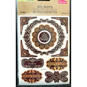 May include: A sheet of 11 decorative stickers with a vintage theme. The stickers feature ornate frames, a large circular design with a floral pattern, and rectangular labels with the words "Enjoy", "Simply Life", "Good Times", and "Special".